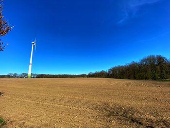 Scenic view of agricultural field against blue sky