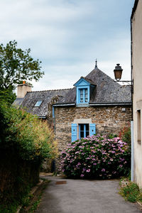 Street amidst houses and buildings against sky