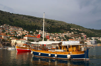 Boats moored at harbor against sky