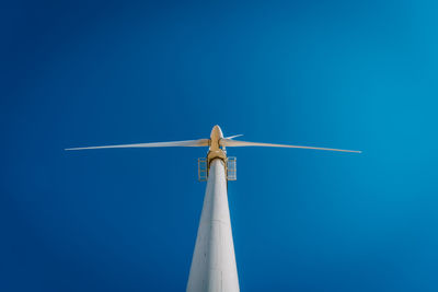 Low angle view of windmill against clear blue sky