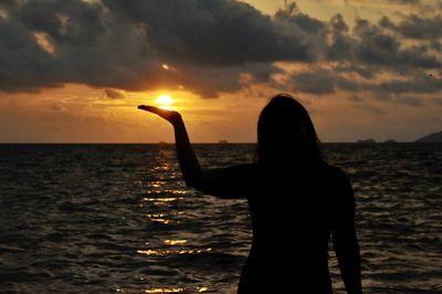 Silhouette of woman at beach during sunset