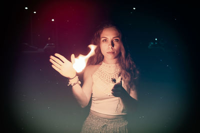 Portrait of beautiful woman standing at night