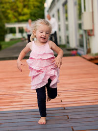 Full length portrait of girl jumping on floorboard