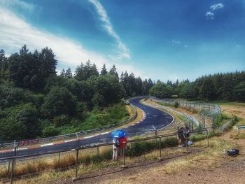 High angle view of road amidst trees against sky