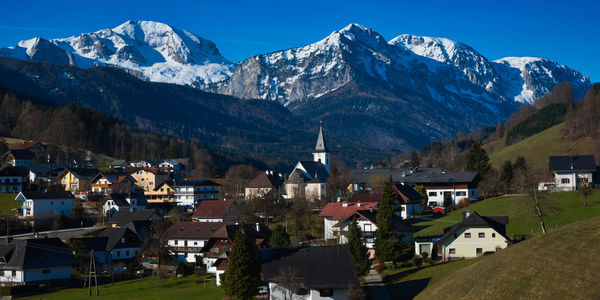 Houses on snowcapped mountain against sky