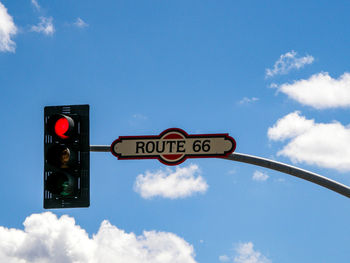 Low angle view of road sign against sky