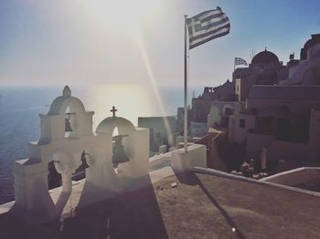 Bell tower with flagpole by sea