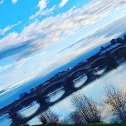 Low angle view of bridge over river against sky