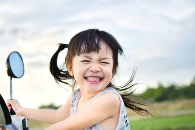 Portrait of smiling girl against sky