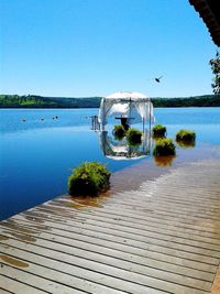 Scenic view of lake against clear blue sky