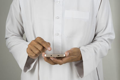 Midsection of man holding mobile phone