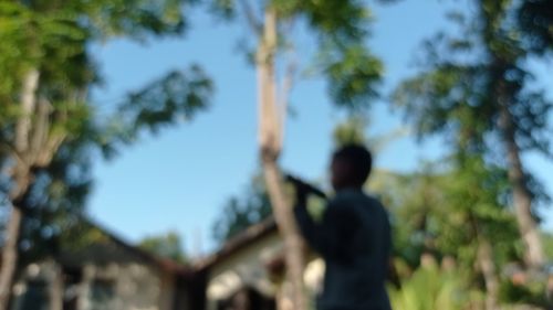 Low angle view of man standing against trees