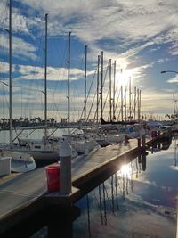 Boats moored at harbor against sky