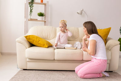 Portrait of smiling couple sitting on sofa at home