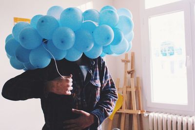 Midsection of man holding balloons