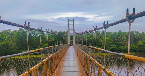 View of footbridge against cloudy sky