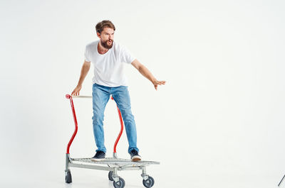 Portrait of young man standing against white background