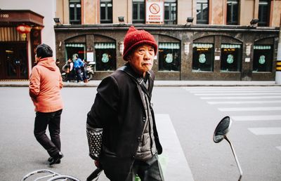 Full length portrait of woman on street in city during winter