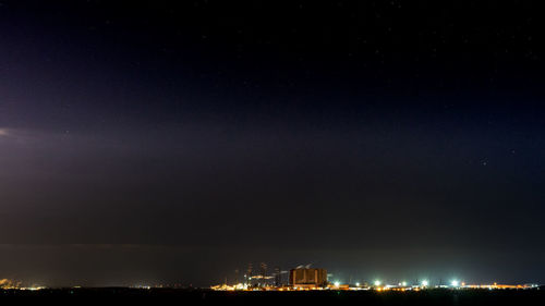 Illuminated city against sky at night