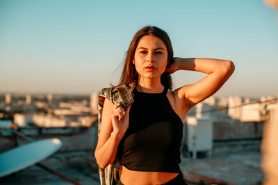 Portrait of young woman on terrace during sunset