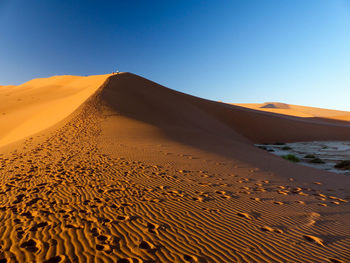 Scenic view of desert against clear blue sky