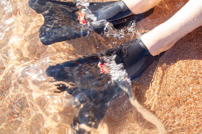 Low section of person standing on sand