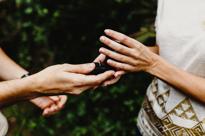 Cropped image of man giving ring to woman