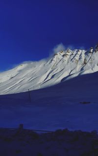 Scenic view of snowcapped mountain against blue sky