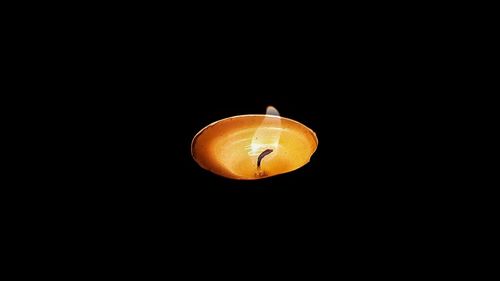 Close-up of illuminated lamp over black background