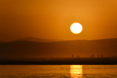 Scenic view of sea against orange sky