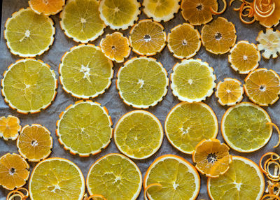 Picture with sliced orange slices on a metal pan preparing for drying, preparing for chrismas