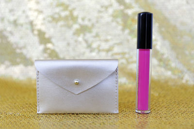 Close-up of pink lipstick and purse on table