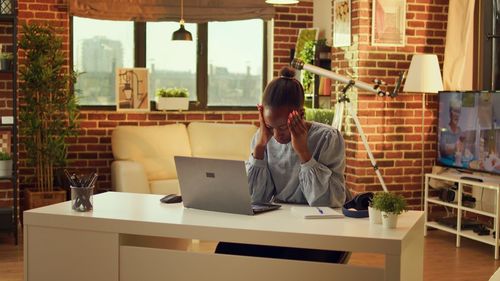 Side view of woman using laptop while standing in creative office