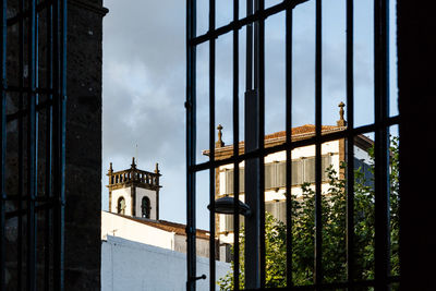 Metal gate of building against sky