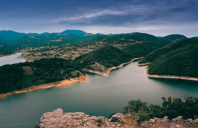 Scenic view of lake and mountains against sky