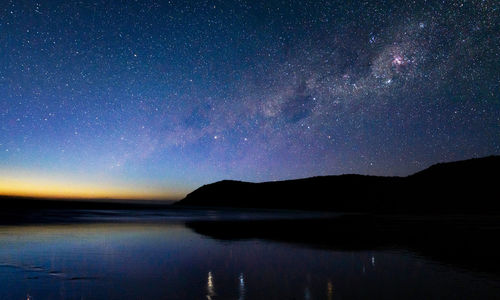 Scenic view of lake against sky at night