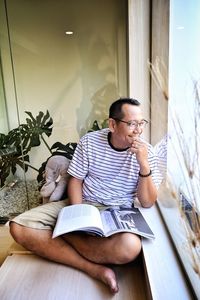 Full length of man sitting on book