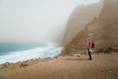 Rear view of man walking at beach