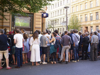 People on street amidst buildings in city