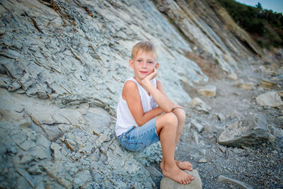 Portrait of boy sitting on rock