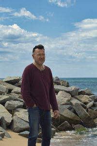 Lonely man on the seashore near a breakwater