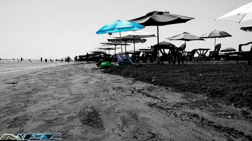 Beach umbrellas on shore against sky