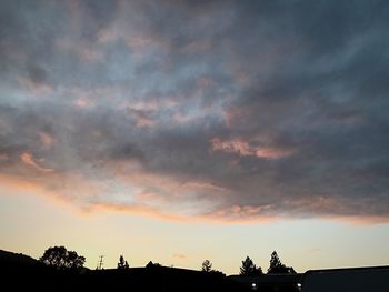 Low angle view of silhouette trees against sky