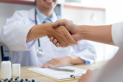 Cropped hands of business colleagues working on table