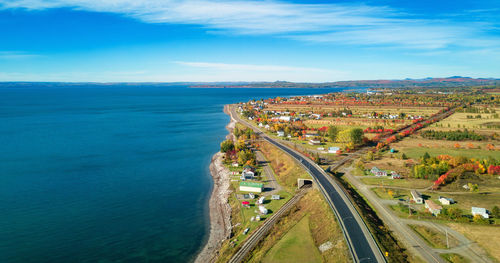 High angle view of city by sea against sky