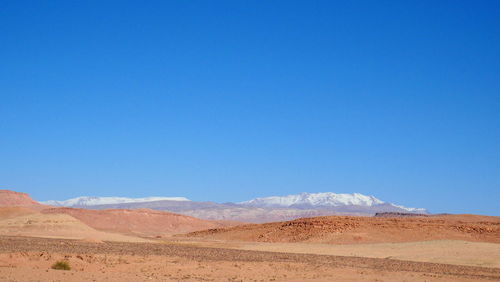 Scenic view of desert against clear blue sky