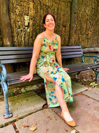 Portrait of a smiling young woman sitting on bench