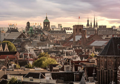 High angle view of buildings in town against cloudy sky