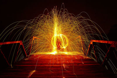 Illuminated ferris wheel against sky at night