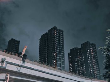 Low angle view of illuminated buildings against sky at night